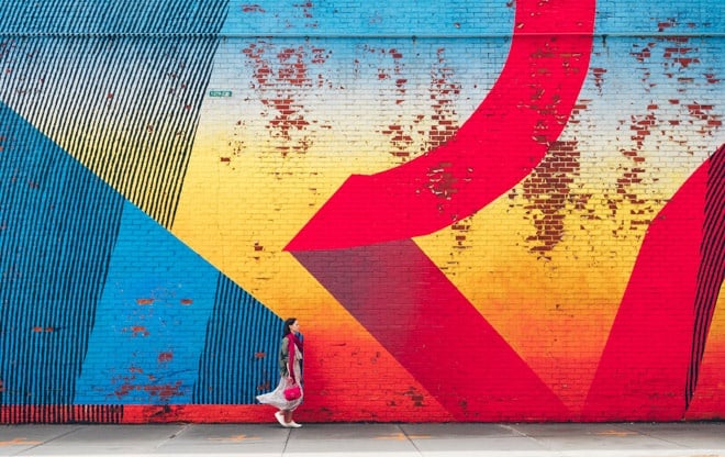 woman standing in front of street mural