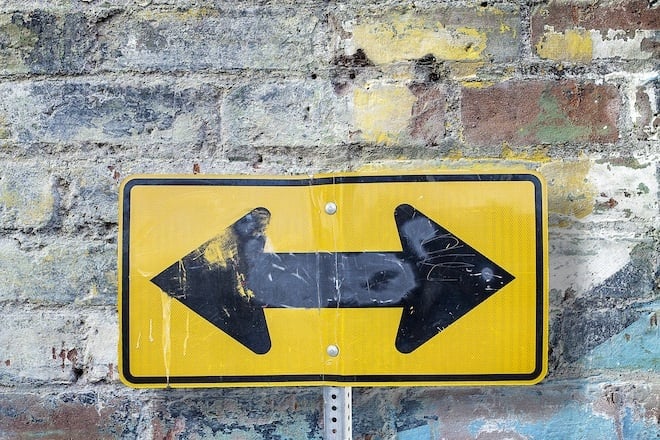 two way sign on a brick wall