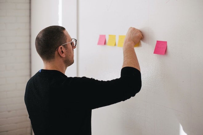 man with sticky notes on wall